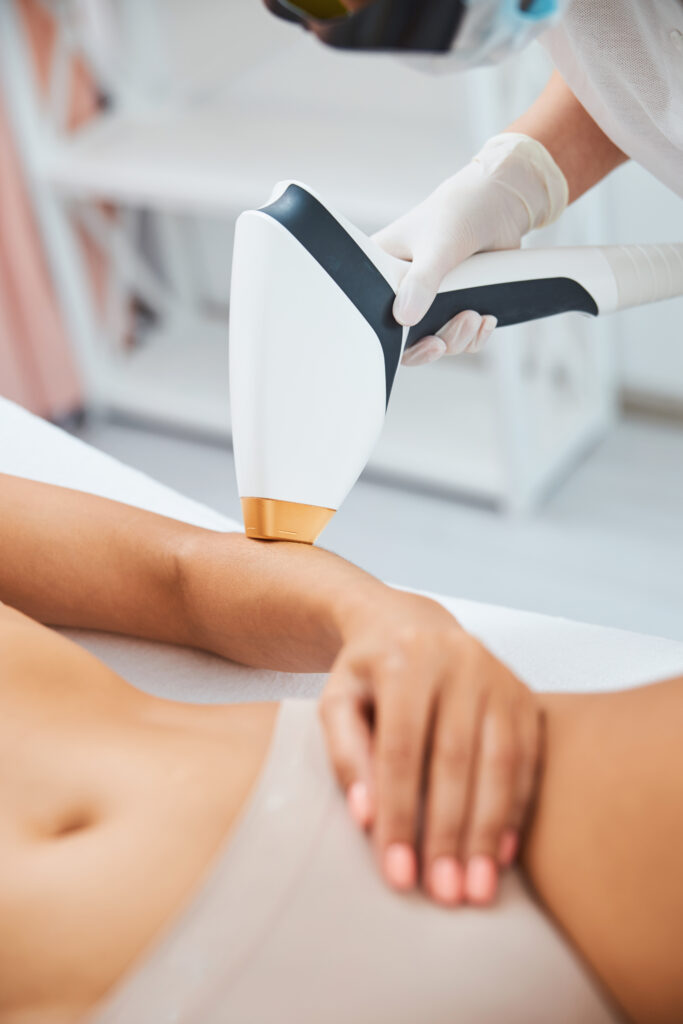 Cosmetician performing an arm laser hair removal